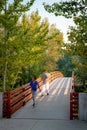 People walking over a foot bridge in a Boise Idaho city park