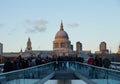 People walking over Millennium bridge at dusk, London, UK