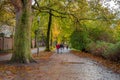 People walking in the park near by the Bruges canal around the town center in autumn rainy day