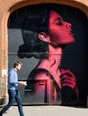 People walking past graffiti street art in Shoreditch, East London England UK Royalty Free Stock Photo