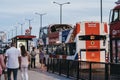 People walking past The Original Tour bus painted as Union Jack, London Bridge, UK