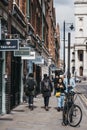 People walking past the shops in Spitalfields Market, London, UK