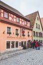 People walking past traditional colourful houses in the old town of Rothenburg ob der Tauber in Germany