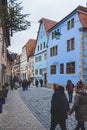 People walking past traditional colourful houses in the old town of Rothenburg ob der Tauber in Germany