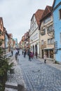 People walking past traditional colourful houses in the old town of Rothenburg ob der Tauber in Germany