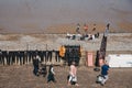 People walking past the wet suits drying in the sun at Surf School in Cromer, Norfolk, UK