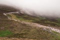 People walking on a path to the top of Croagh Patrick, Westport, county Mayo, Ireland. Low clouds covering the peak. Pilgrimage Royalty Free Stock Photo