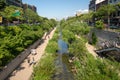 People walking on paths along an urban creek