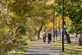 People walking with pet in the Bow River Pathway in autumn. Downtown Calgary