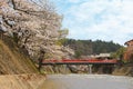 People walking on red Nakabashi Bridge during Spring in Takayama, Japan