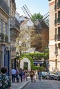 People walking in rue Lepic, view on the famous Moulin de Galette on the hill of Montmartre in Paris France