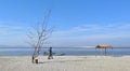 People walking on a sandy beach at Panikhaiti, picnic spot near Guwahati, Assam, India