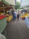 People walking by and shopping at the stands of a public open market, feira livre, in Sao Paulo.