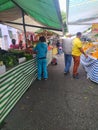 People walking by and shopping at the stands of a public open market, feira livre, in Sao Paulo