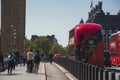 People walking on sidewalk and doubledecker buses moving on road in London Royalty Free Stock Photo