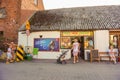 People walking and sitting in front of a small grocery store in Sarbinowo, Poland