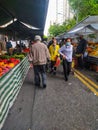 People walking among the stands of a street open market in Sao Paulo, Brazil, known as feira livre.