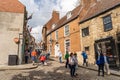 People walking Steep Hill, Lincoln, UK, a popular tourist attraction in the city.