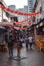 People walking on a street with decorative paper lanterns in Singapore China Town