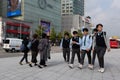 People walking on the street. Different generations of pedestrians: group of three aged women, group of teenagers in school