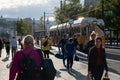 People walking on the street in front of a yellow streetcar