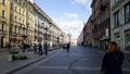 People walking on a street in St. Petersburg, Russia with buildings and lightposts clear day