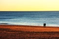 People walking at sunset on the beach of Cadiz capital, Andalusia. Spain. Royalty Free Stock Photo