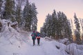 People walking in sunset or sunrise in mountains in winter. Beautiful pink sky