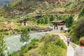 People walking towards the Iron Bridge of Tamchog Lhakhang Monastery, Paro River, Bhutan.