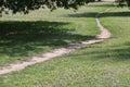 People walking on a trail in an open green field. Royalty Free Stock Photo