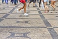 People walking in a typical Portuguese street paved in little stone Royalty Free Stock Photo