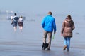 People walking on an east coast beach at low tide.