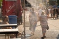 People walking under misting system to cool off during heatwave Royalty Free Stock Photo