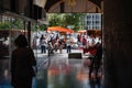 People walking via tunnel toward market stall in central Strasbourg during the