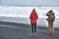 People walks on black sand beach of Reynisfjara in south of Iceland