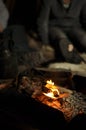 People warming up by the campfire. Coffee pot in closeup. Reindeer skin to sit on when you grill and cook