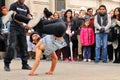 People watch a homeless streetdancer doing breakdance and dance moves in the streets of Paris Royalty Free Stock Photo