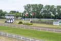 People watch trotting derby, Sunshine on the trotting track. Horses, Jocky, Sulky Royalty Free Stock Photo