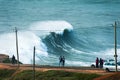 People watching big waves in Nazare, Portugal. Coast of Atlantic ocean in autumn