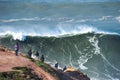 People watching big waves in Nazare, Portugal