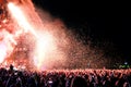 People watching a concert by the famous band Arcade Fire, while throwing confetti from the stage