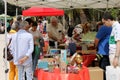 People are watching and selling things in a street antiques and books stand