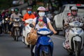 People wearing face masks riding motorcycle on Pham Van Dong street