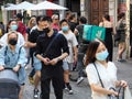 People wearing face masks walking and biking on a busy street in Milan, Italy Royalty Free Stock Photo