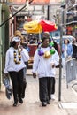 People wearing funny costumes celebrating famous Mardi Gras carnival on the street in French Quarter.