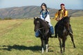 People wearing traditional national dresses ride on horseback at countryside, Almaty, Kazakhstan. Royalty Free Stock Photo