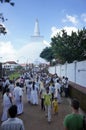 People in white robes walk to the sacred stupa Ruwanweliseya, which was built by King Dutugamunu in 140 BC, during the Poya