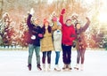 Happy friends ice skating on rink outdoors Royalty Free Stock Photo