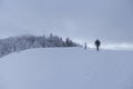 Couple man woman hikers in snow winter season walk to forest in Beskids mountains. Sport active people hiking trail to Mogielnica. Royalty Free Stock Photo