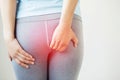 People woman hand holding her bottom because having abdominal anal pain and suffering from hemorrhoids,
